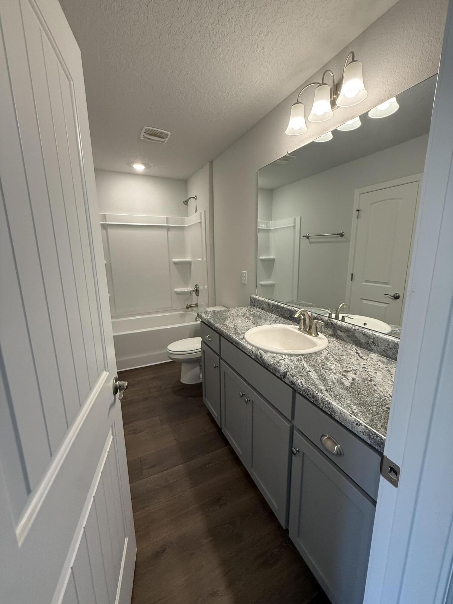 6004 Crocket Cove Crestview, FL 32539 - Photo 9 of 24 a bathroom with a granite countertop sink mirror and a bathtub