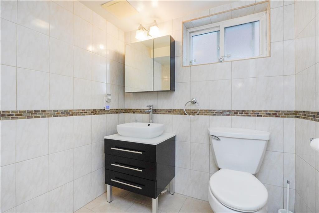 151 81st Street Brooklyn, NY 11209 - Photo 21 of 37 a bathroom with a toilet sink and mirror