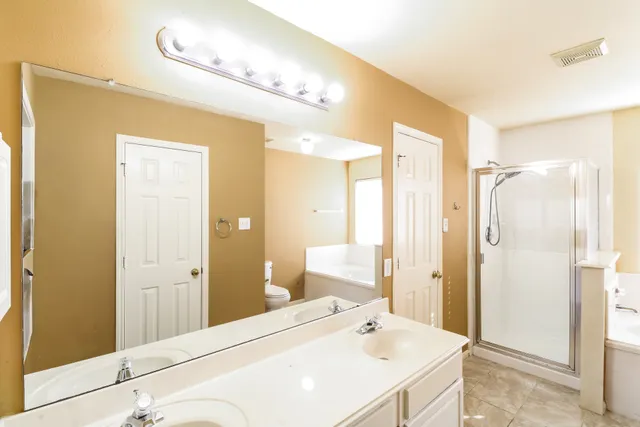 a en suite bathroom with a shower sink and mirror