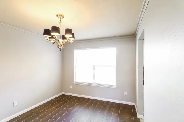 a view of a room with wooden floor and chandelier