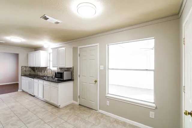 a kitchen with stainless steel appliances a sink a stove a refrigerator a window