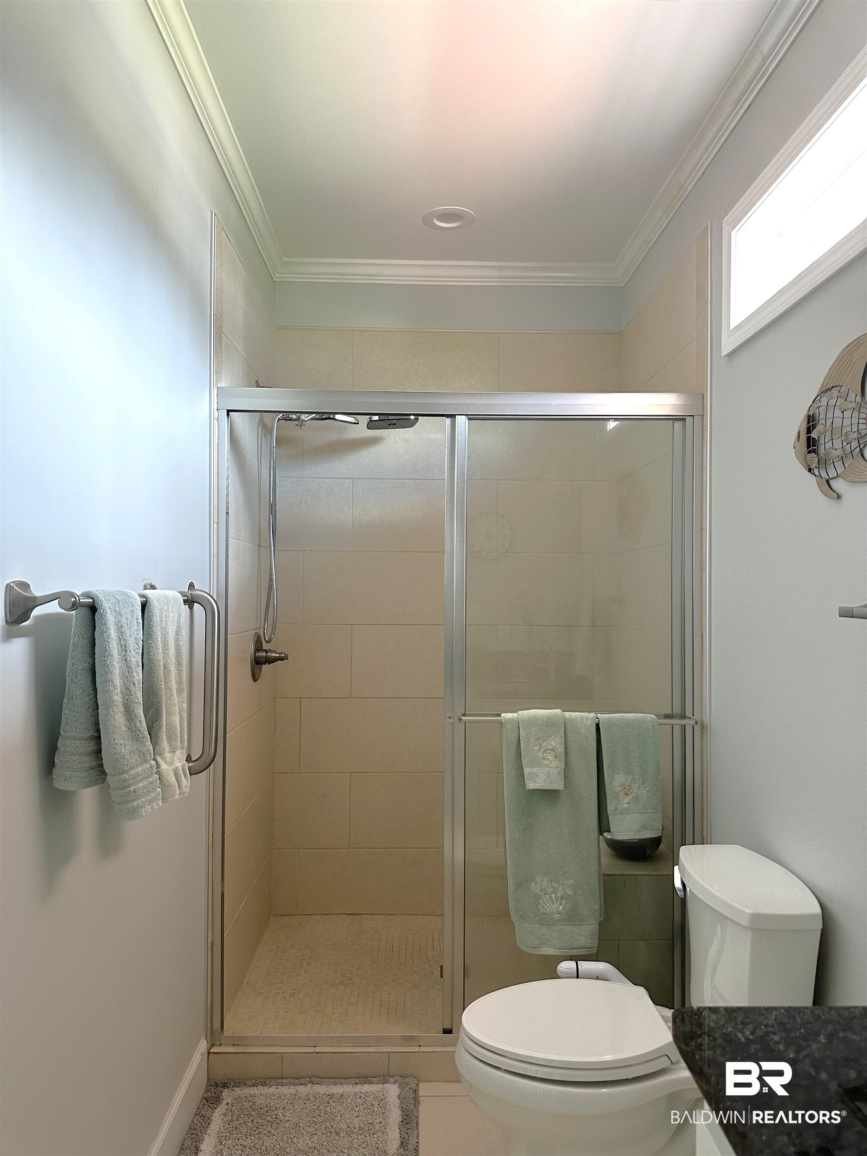 12136 Gateway Drive Elberta, AL 36530 - Photo 15 of 34 Bathroom with toilet, crown molding, and a shower with shower door