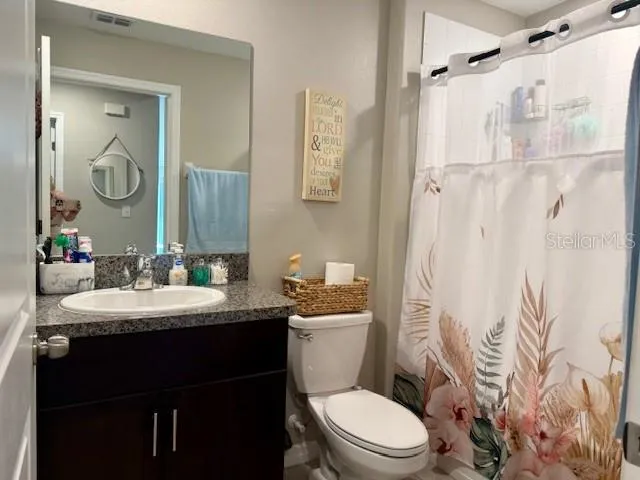 a bathroom with a sink toilet vanity and shower