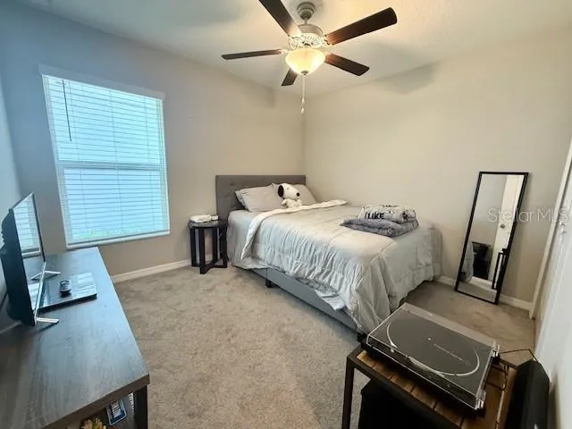 a bedroom with a bed and a flat tv screen on dresser