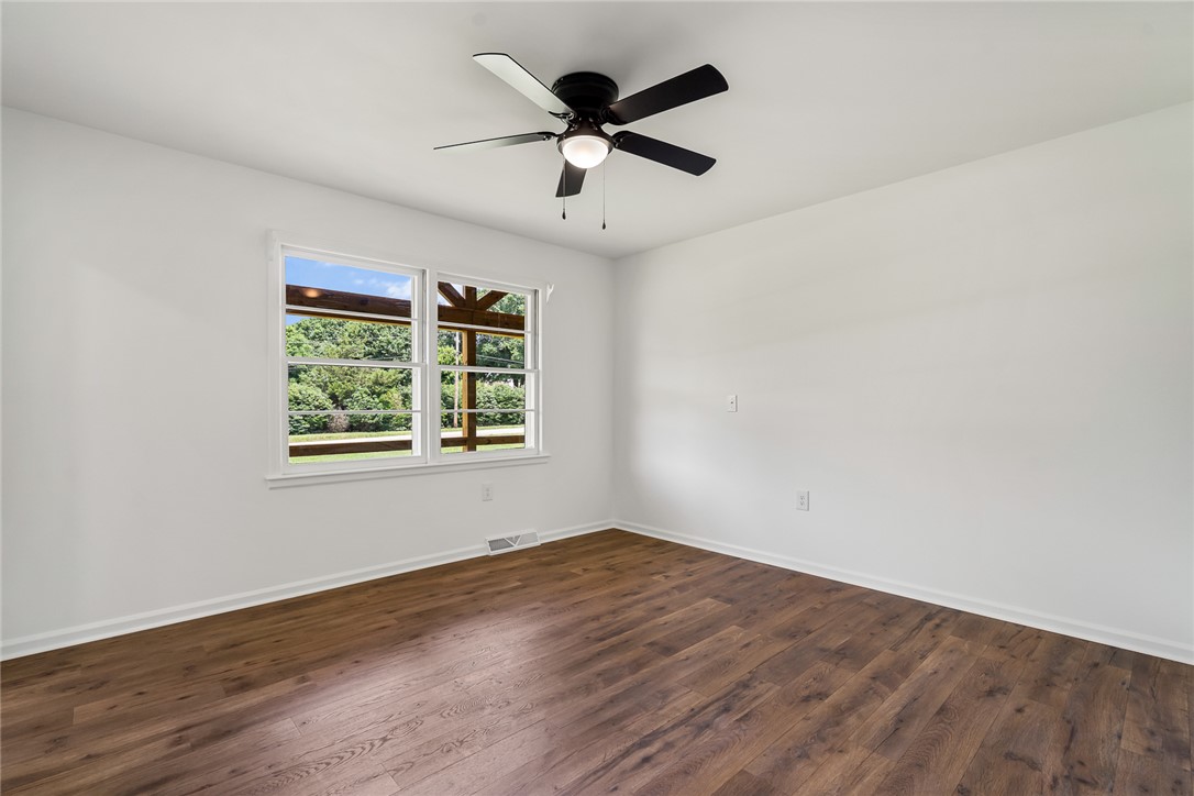 300 Vandiver Road Anderson, SC 29621 - Photo 14 of 30 Hardwood floors and a ceiling fan create a comfortable and inviting atmosphere in this sun-filled bedroom.