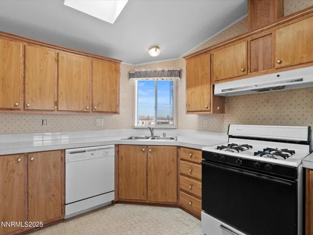 a kitchen with stainless steel appliances granite countertop a stove a sink dishwasher and a microwave