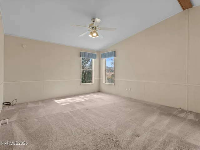 en empty room with windows and chandelier fan