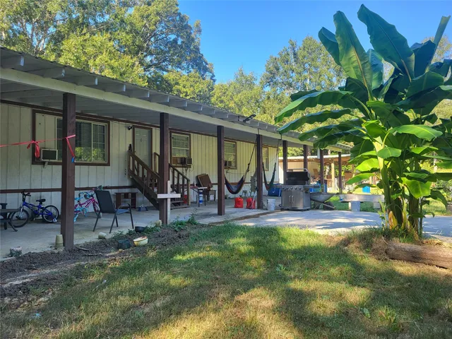 a view of a patio with table and chairs and a large tree