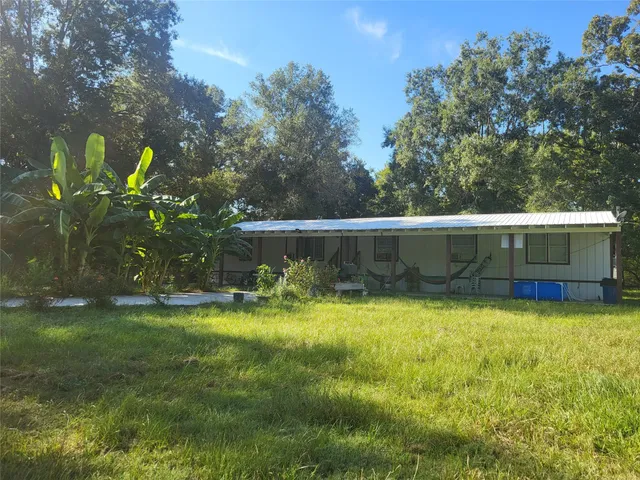 a swimming pool with outdoor seating and yard