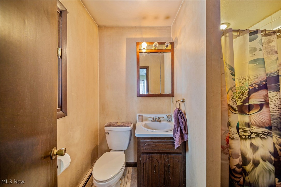 12430 Butternut Road Chardon, OH 44024 - Photo 22 of 33 Full bath featuring a shower with shower curtain, toilet, vanity, tile patterned flooring, and baseboards