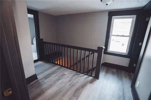 a view of a hallway with wooden floor and stairs