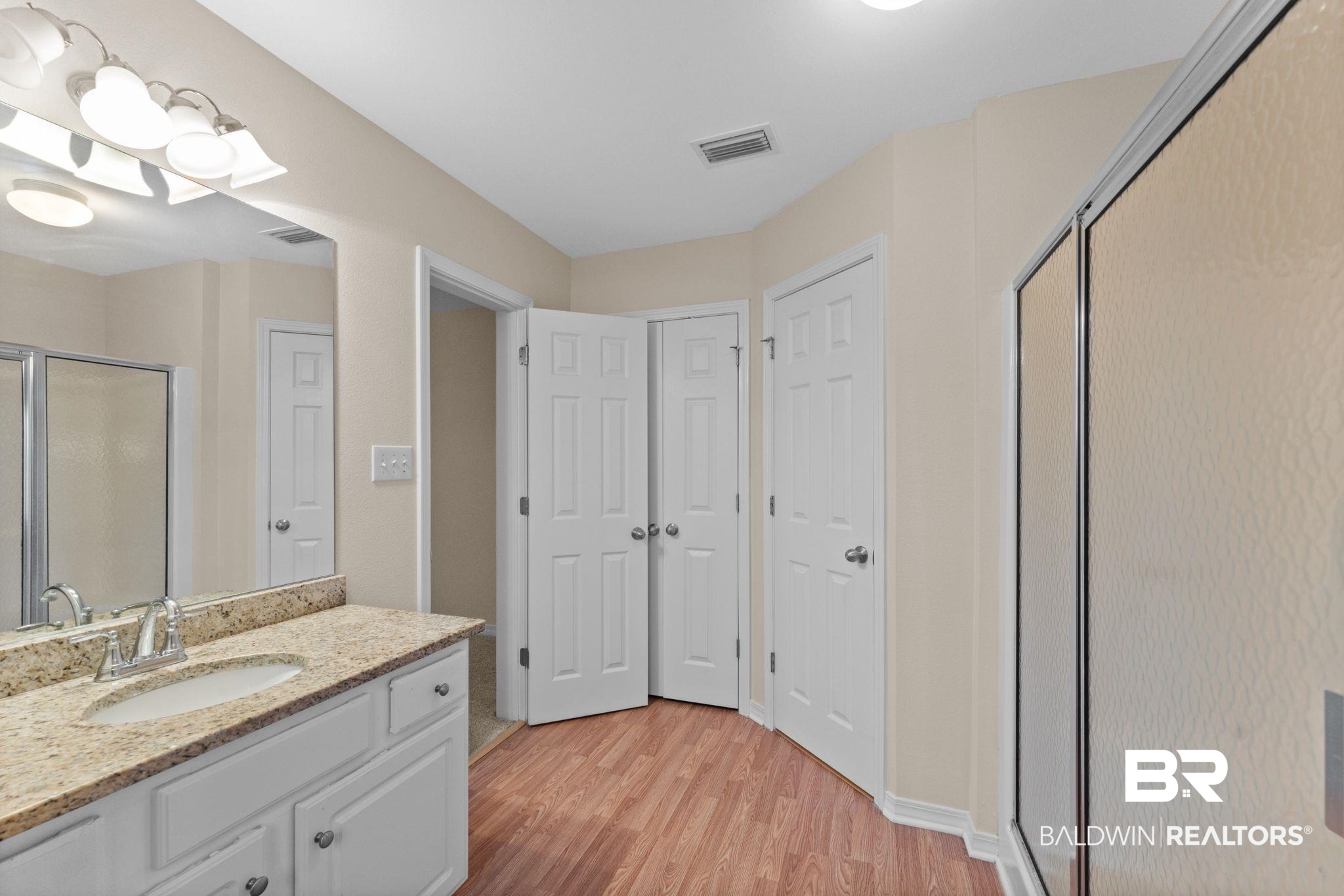 4009 Kendallbrook Loop Foley, AL 36535 - Photo 20 of 28 Bathroom with a stall shower, vanity, and light wood-style floors