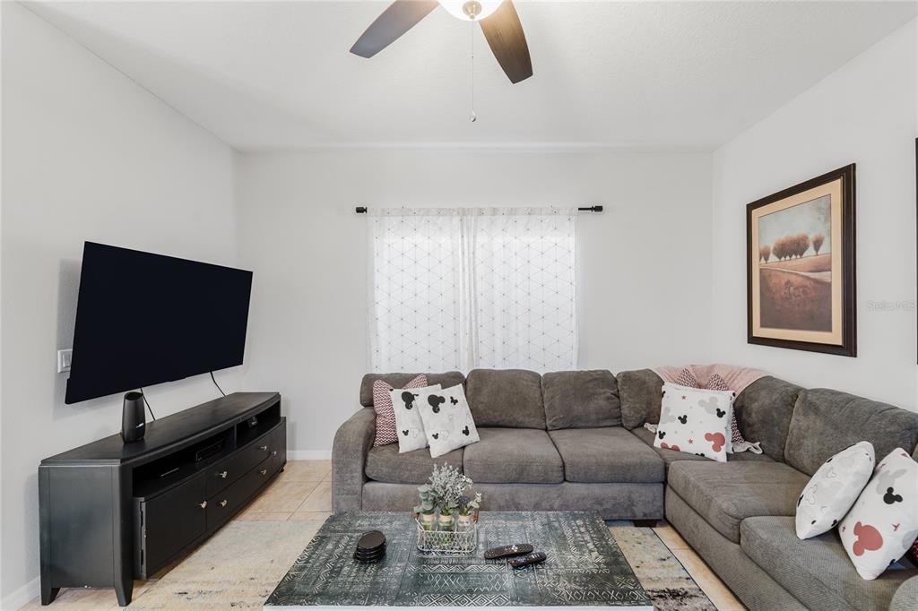 8961 Majesty Palm Road Kissimmee, FL 34747 - Photo 14 of 40 a living room with furniture and a flat screen tv