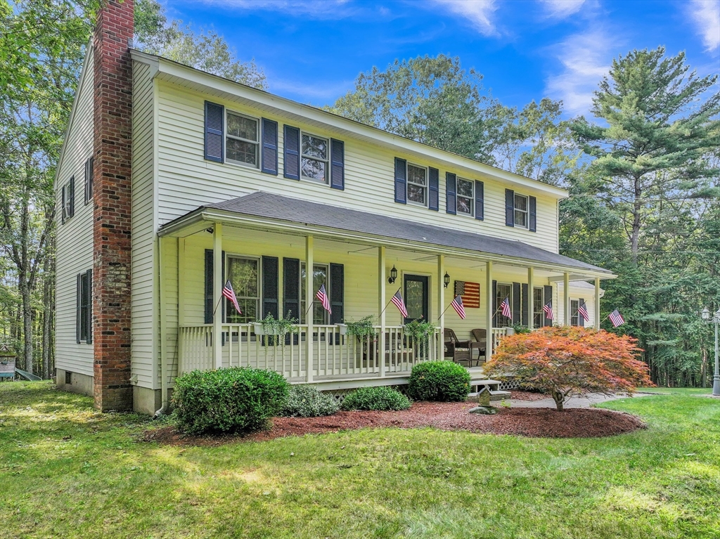 a front view of a house with a yard and potted plants