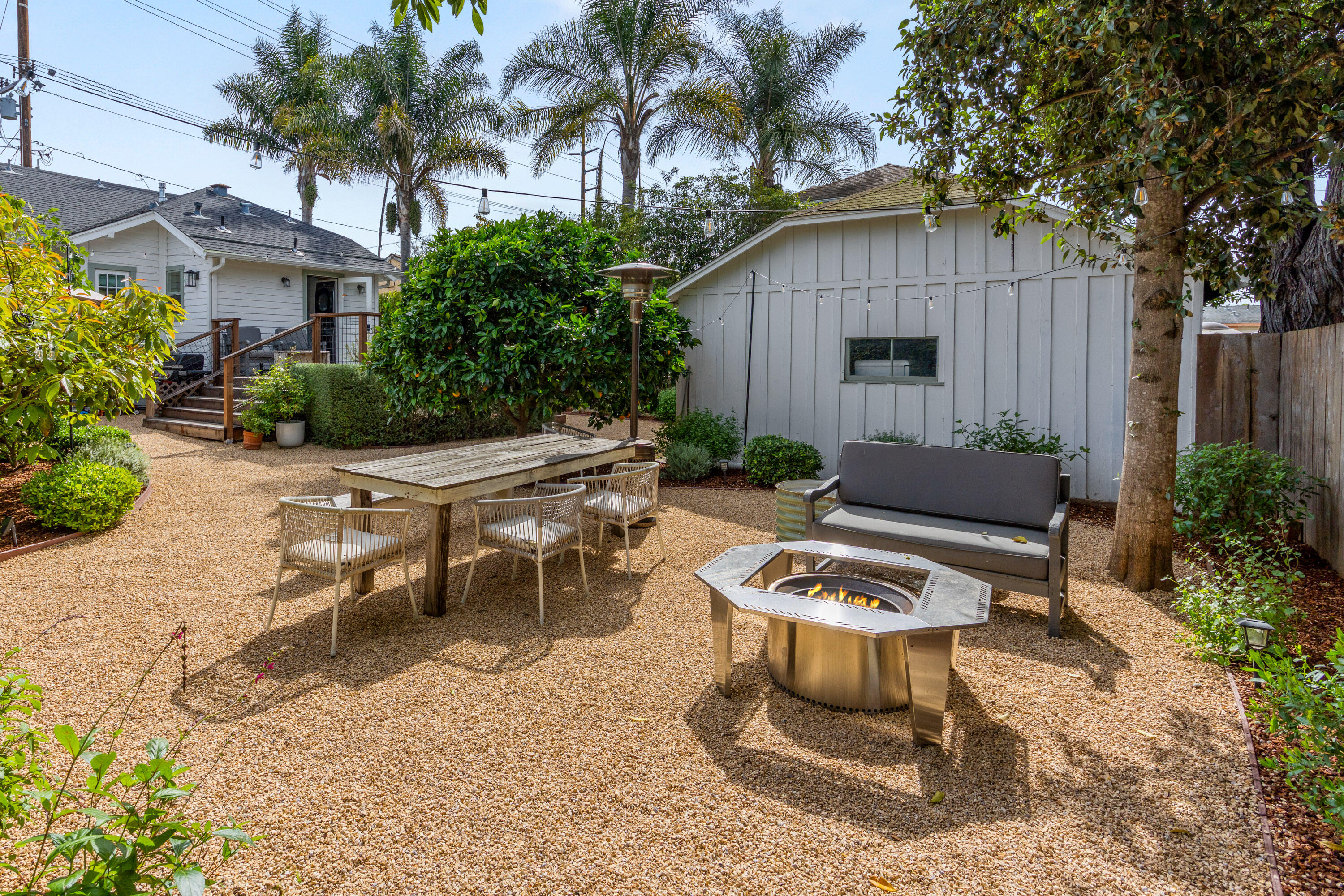 321 North Soledad Street Santa Barbara, CA 93103 - Photo 18 of 25 a view of a backyard with table and chairs potted plants and wooden fence