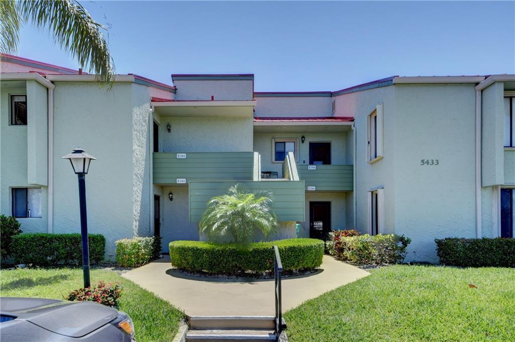 5433 Southeast Miles Grant Road, Unit E203 Stuart, FL 34997 - Photo 1 of 42 a front view of a house with garden