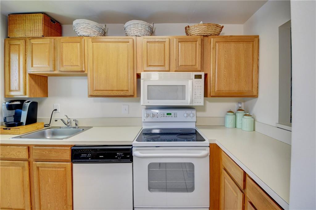 5433 Southeast Miles Grant Road, Unit E203 Stuart, FL 34997 - Photo 12 of 42 a kitchen with stainless steel appliances granite countertop a sink stove and cabinets