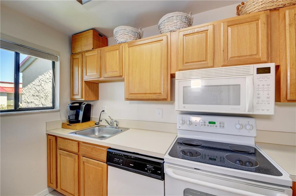 5433 Southeast Miles Grant Road, Unit E203 Stuart, FL 34997 - Photo 13 of 42 a kitchen with stainless steel appliances a stove a sink cabinets and a window