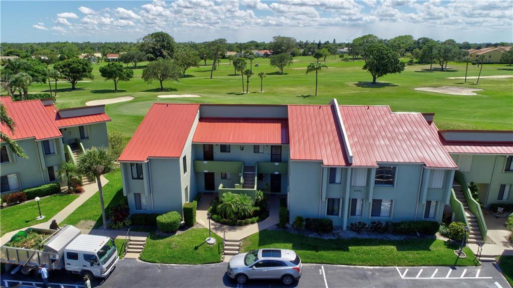 5433 Southeast Miles Grant Road, Unit E203 Stuart, FL 34997 - Photo 29 of 42 a front view of a house with a garden and trees