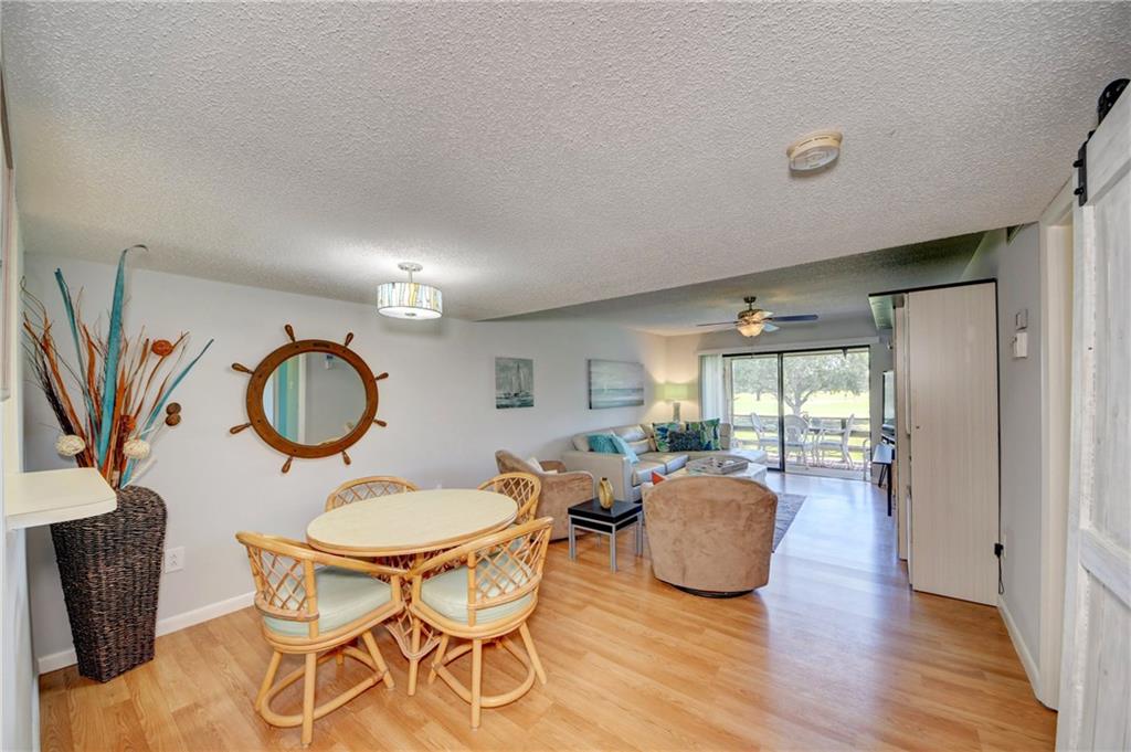 5433 Southeast Miles Grant Road, Unit E203 Stuart, FL 34997 - Photo 4 of 42 a living room with furniture a large window and wooden floor