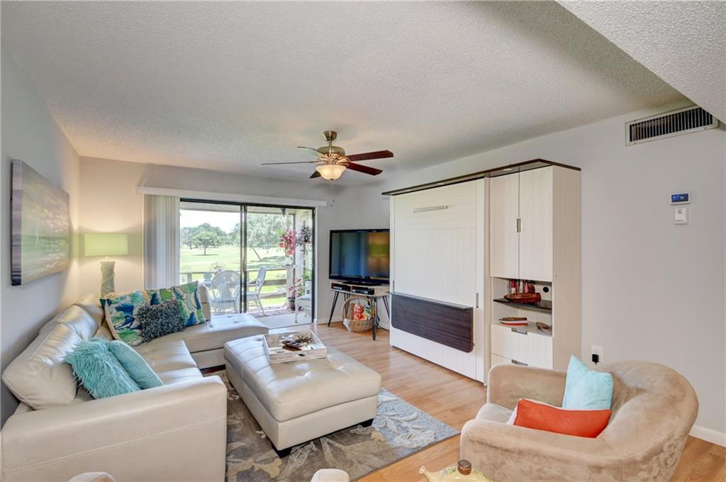 5433 Southeast Miles Grant Road, Unit E203 Stuart, FL 34997 - Photo 6 of 42 a living room with furniture fireplace and a flat screen tv