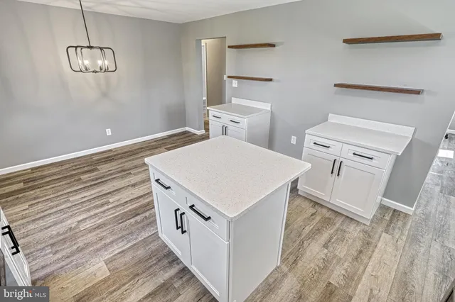 a kitchen with granite countertop a sink and white cabinets
