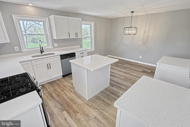 a kitchen with white cabinets and a window