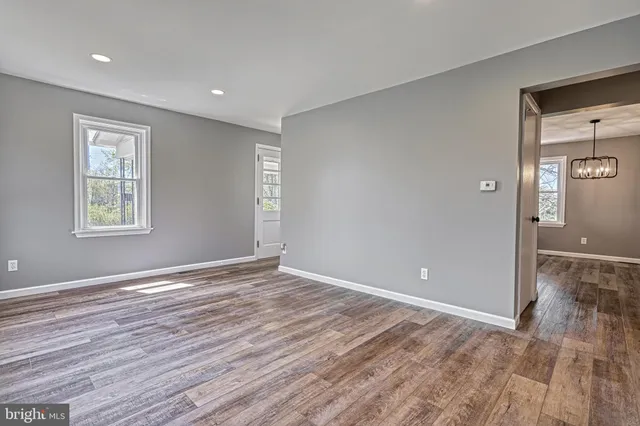 a view of empty room with wooden floor and window