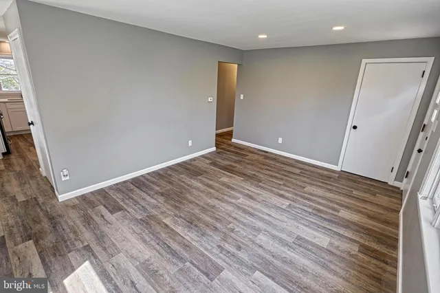 a view of empty room with wooden floor and ceiling fan