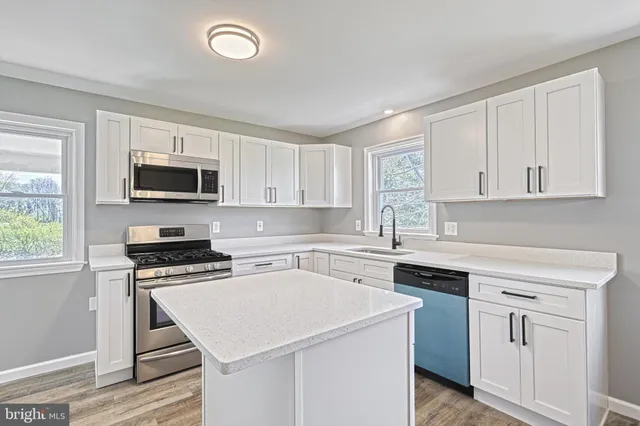a kitchen with a stove a sink and a window