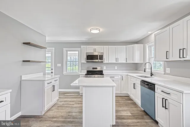 a kitchen with stainless steel appliances granite countertop a stove sink and microwave