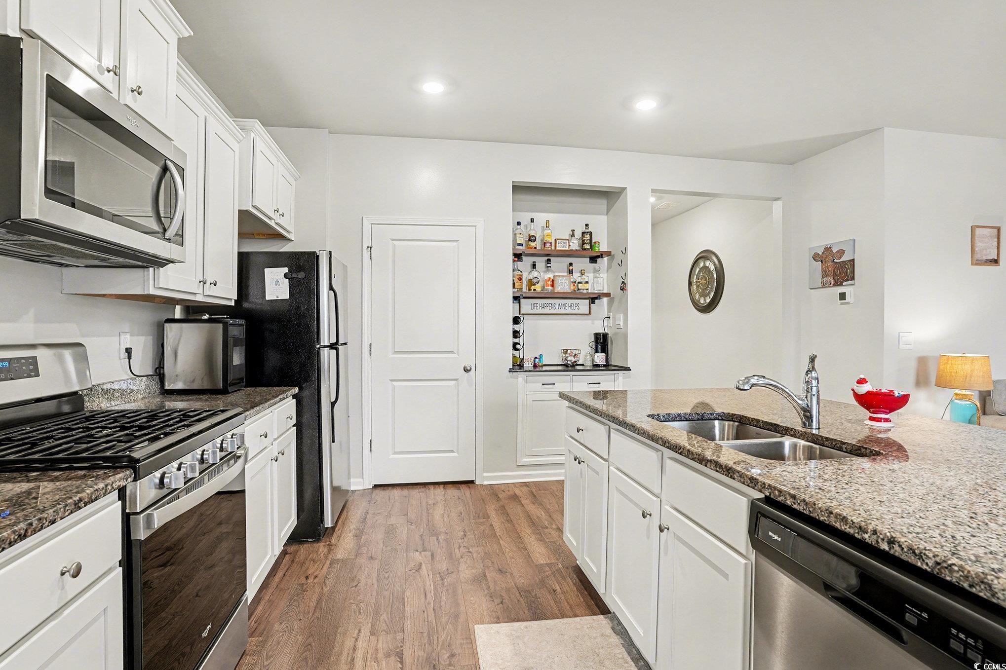 3923 Nandina Court Conway, SC 29526 - Photo 12 of 28 Kitchen with stainless steel appliances, white cabinetry, dark stone counters, and dark wood-style floors
