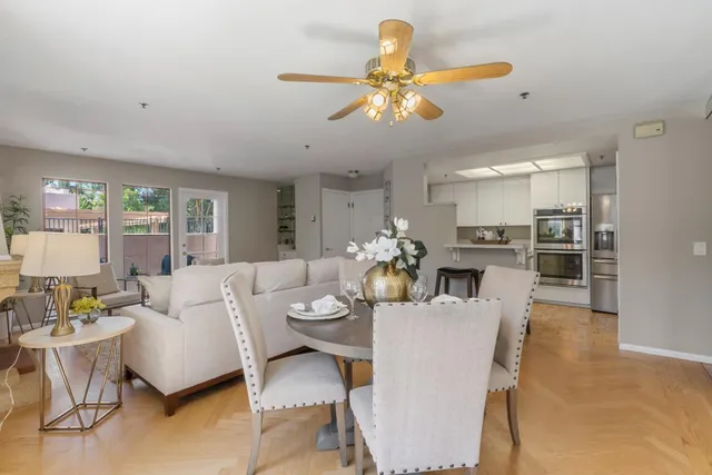 a living room with furniture kitchen view and a chandelier