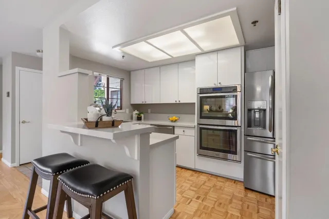 a kitchen with a sink cabinets stainless steel appliances and a window