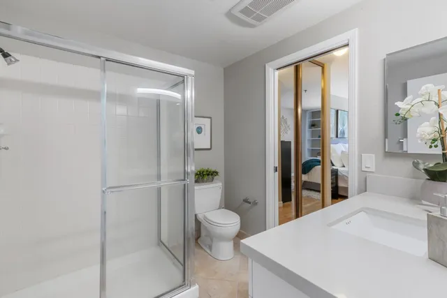 a large white room with a glass door shower
