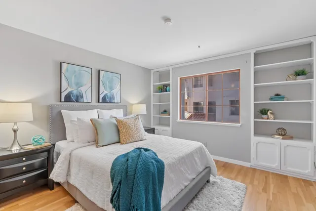 a bedroom with a bed and wooden floor