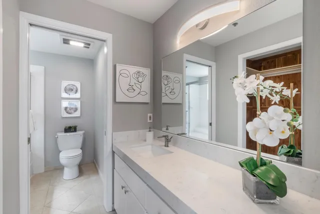 a bathroom with a granite countertop sink mirror and toilet