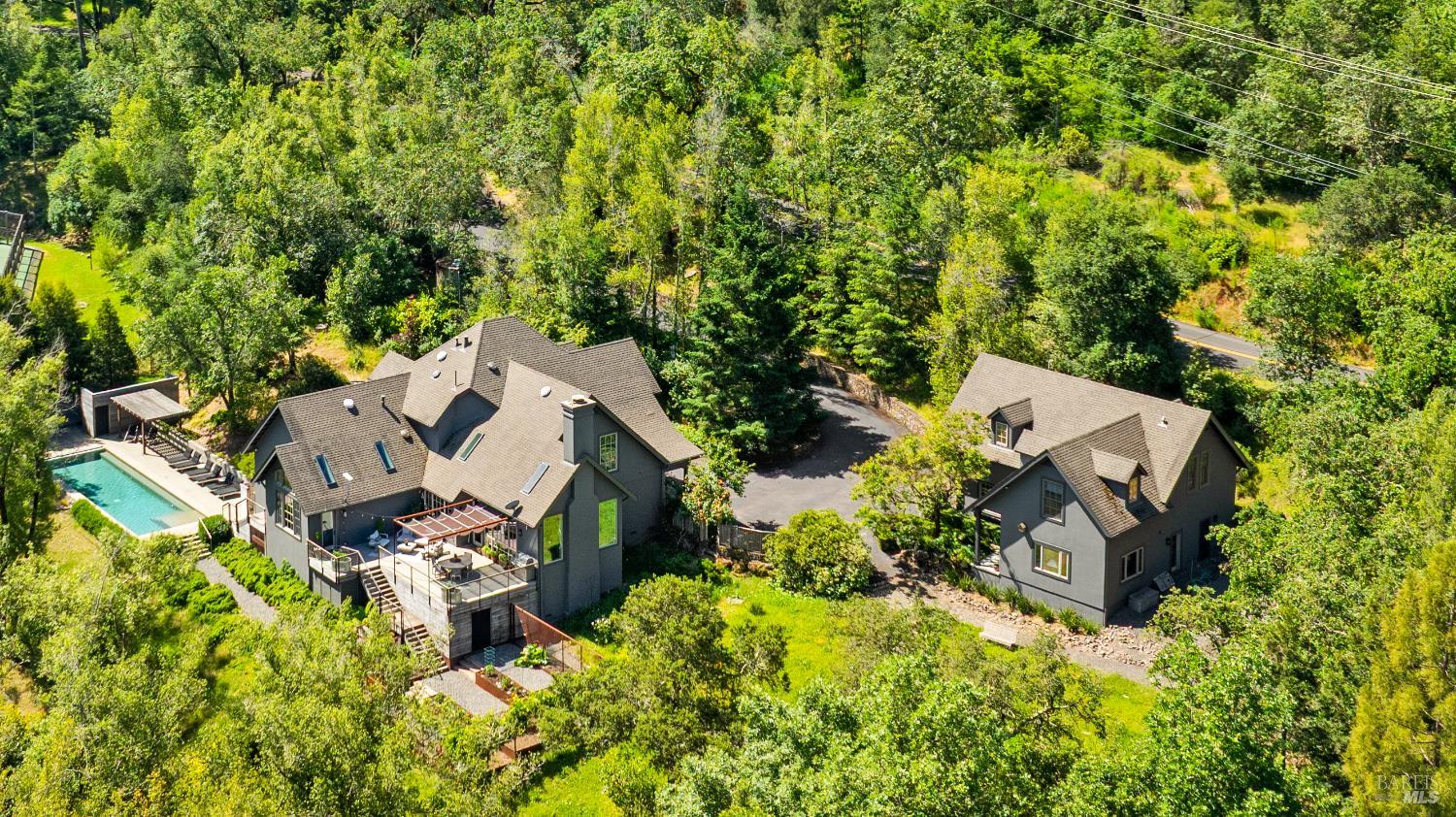 an aerial view of a house with a yard and trees