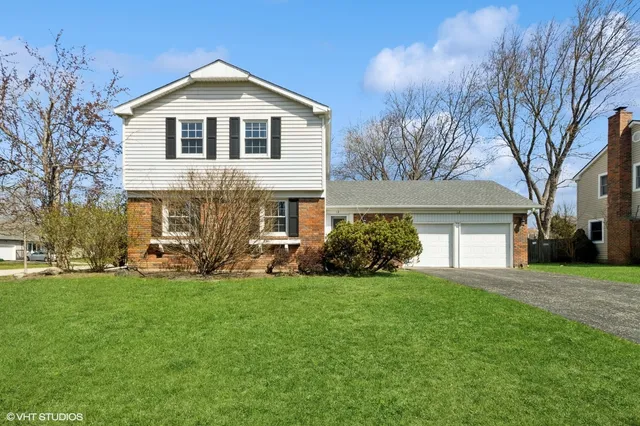 a front view of a house with a yard and trees