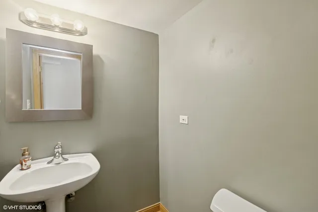 a bathroom with a sink a toilet and mirror