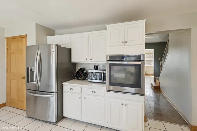 a kitchen with stainless steel appliances a refrigerator sink and cabinets