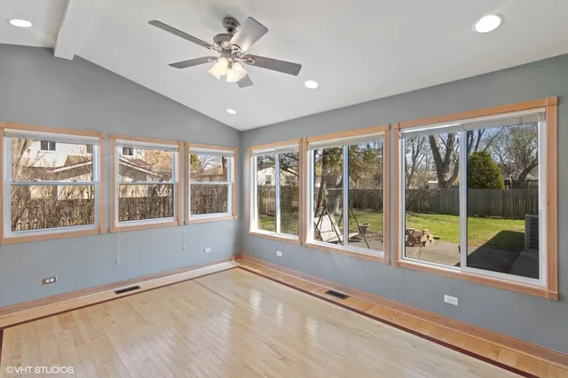 a view of an empty room with a large window with kitchen view