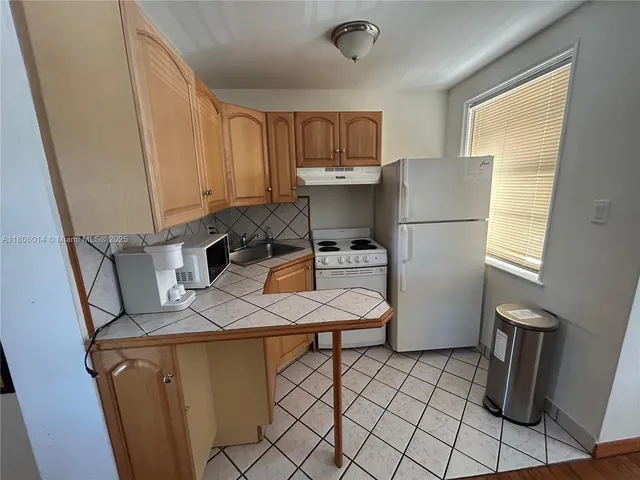 a room with furniture a refrigerator and a window