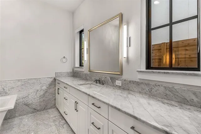 a bathroom with a granite countertop sink a mirror and a shower
