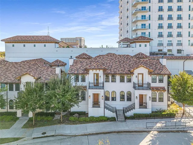an empty room with wooden floor fireplace and windows