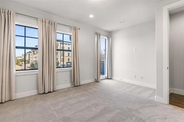 an empty room with windows and flat screen tv