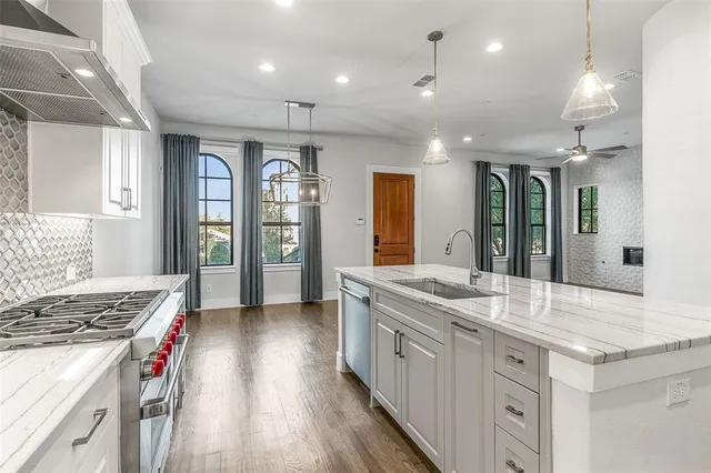 a kitchen with stainless steel appliances granite countertop a sink stove and refrigerator