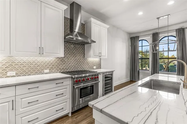 a kitchen with stainless steel appliances granite countertop a stove and a white cabinets