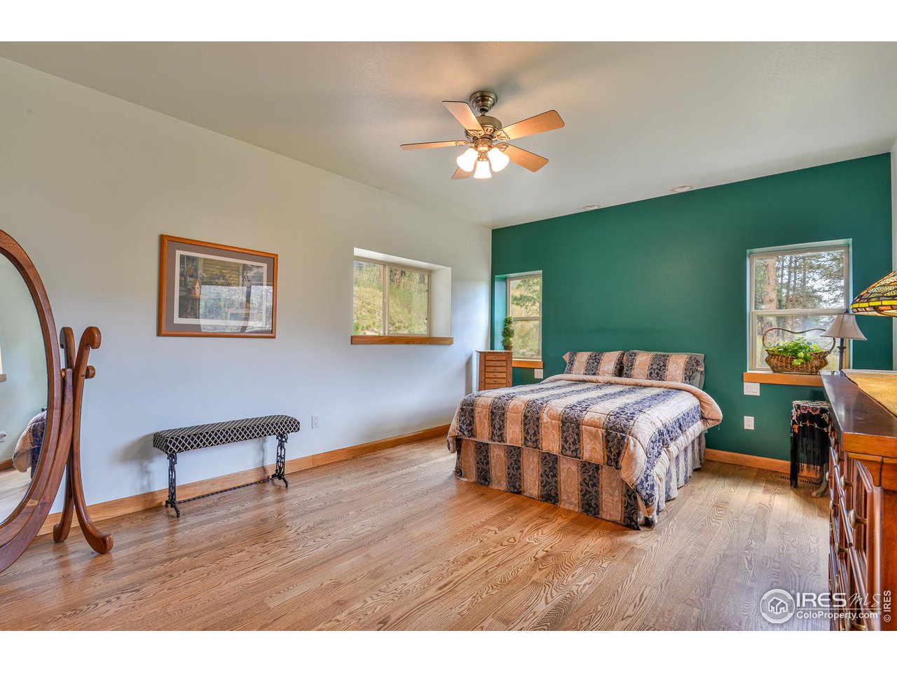 560 Stove Prairie Road Bellvue, CO 80512 - Photo 14 of 40 a bedroom with a bed and a chandelier