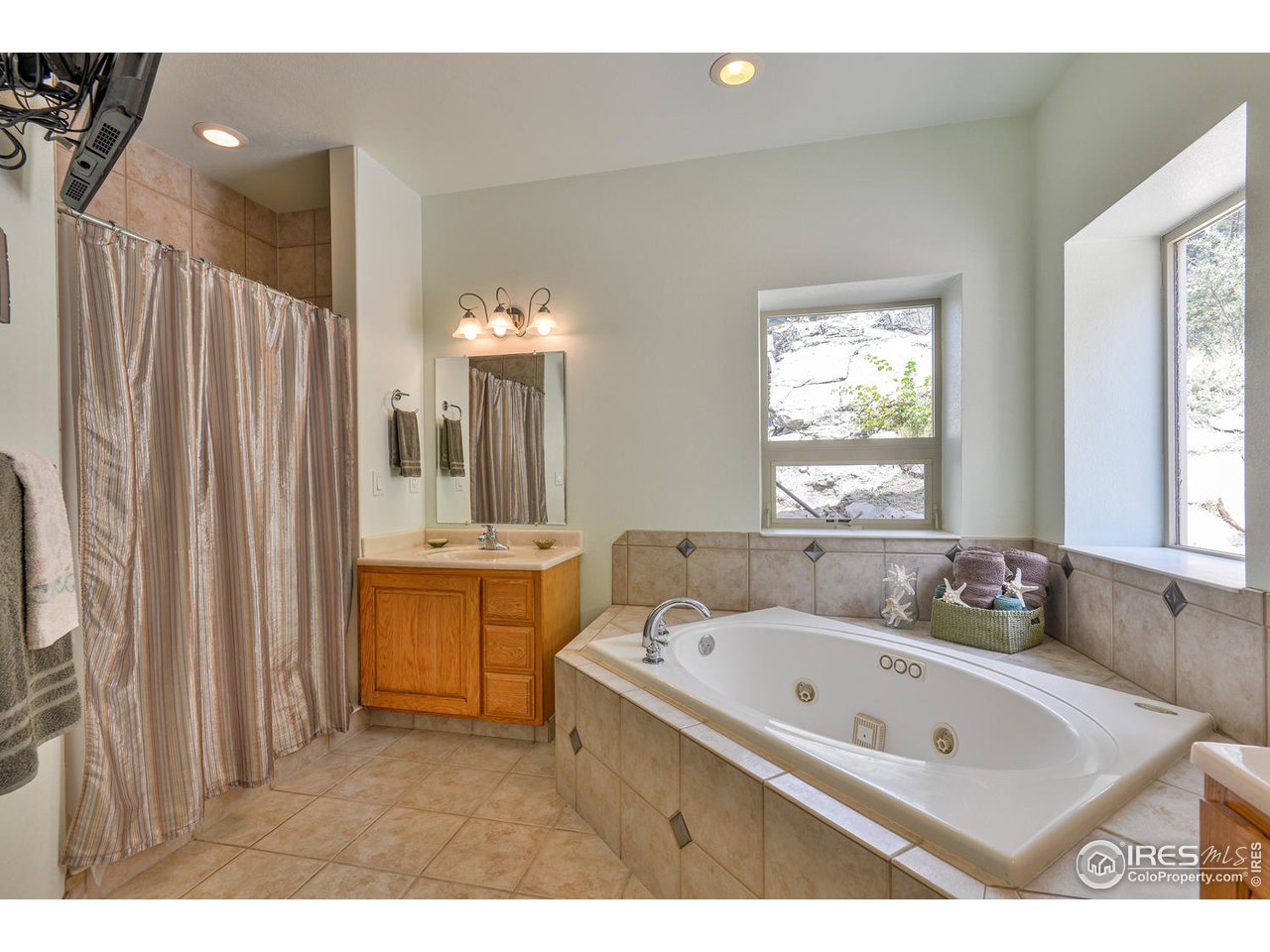 560 Stove Prairie Road Bellvue, CO 80512 - Photo 18 of 40 a bathroom with a tub sink and mirror